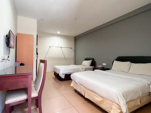 a hotel room with two beds and a desk at N9 Business Hotel Sdn Bhd in Nilai
