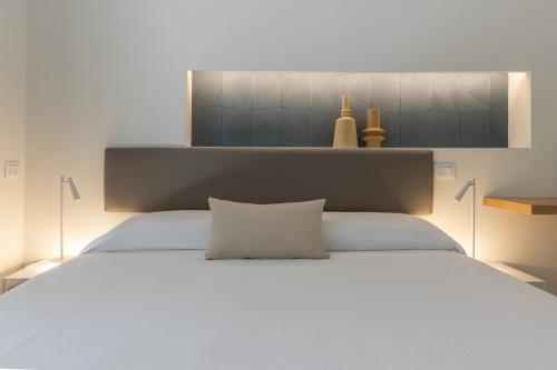 a large white bed with a white pillow on it at Taormina Town - Guesthouse Sicily in Taormina