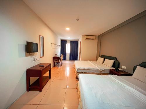 a hotel room with two beds and a desk at N9 Business Hotel Sdn Bhd in Nilai