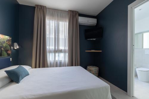 a bedroom with a white bed and a blue wall at Taormina Town - Guesthouse Sicily in Taormina