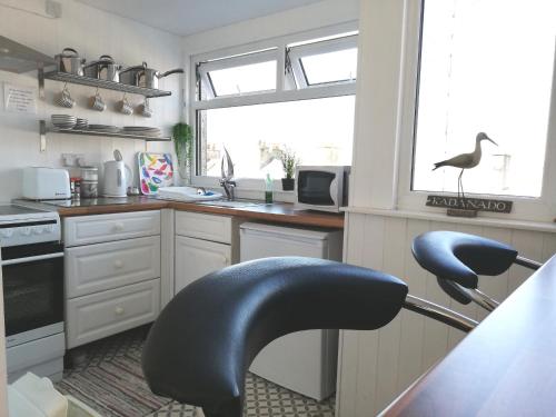 a black chair in a kitchen with a sink at Uwch Menai in Y Felinheli