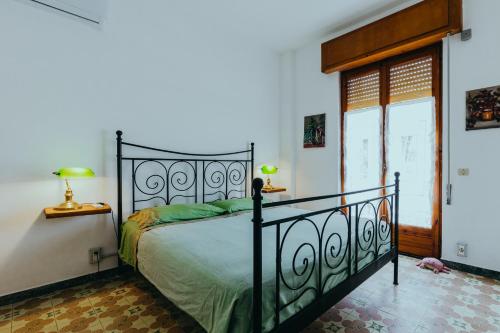 a bedroom with a bed and two lamps and a window at Cuore di Ognina - Appartamenti vista mare in Ognina