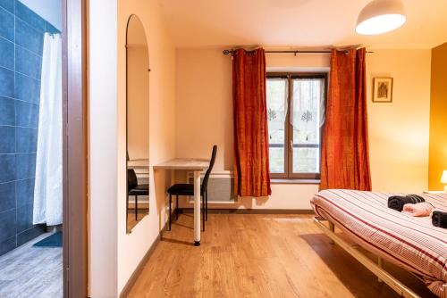 ein Schlafzimmer mit einem Schreibtisch und einem Bett und einem Fenster in der Unterkunft Le LENNON - Centre Ville T2 - Rez-de-chaussée in Limoges