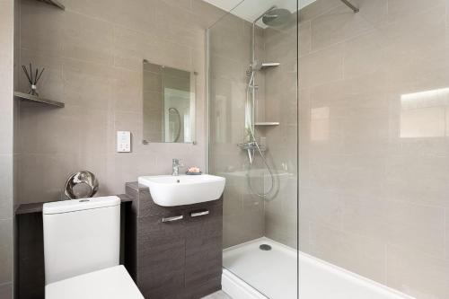 a bathroom with a shower and a toilet and a sink at Stylish Serviced Apartment in Reading in Reading
