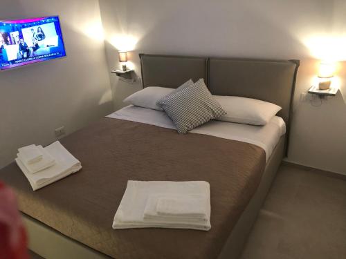 una piccola camera da letto con un letto con asciugamani sopra di Casa Chartù -luxury house- a Conversano