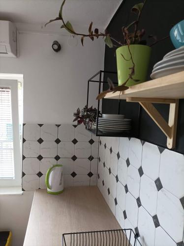 a kitchen with black and white tiles on the wall at Apartment Seventh Continent in Šibenik