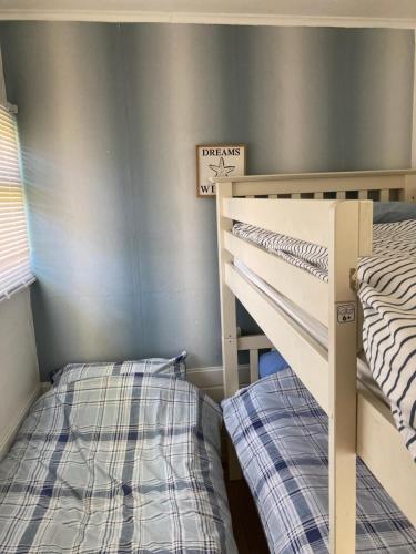 two bunk beds in a room with a wall at Chalet 65 in Chapel Saint Leonards