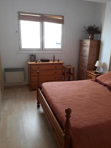 a bedroom with a bed and a dresser and two windows at Nautic in L'Ametlla de Mar