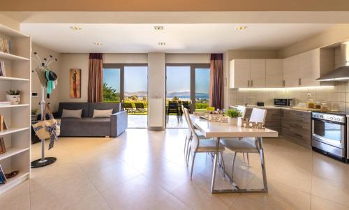 a kitchen and living room with a table and chairs at Villa Kos View 1 in Platánion