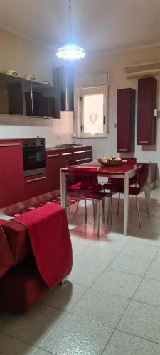 a kitchen with a red table and chairs in a room at Giusy's Place 2.0 in Campofelice di Roccella