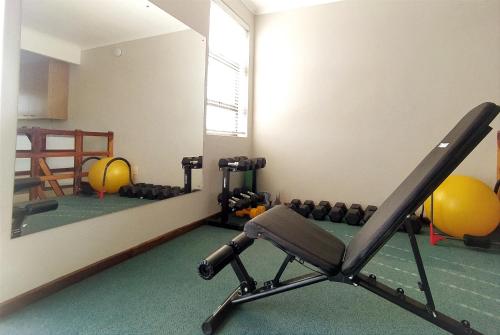a room with a gym with a mirror and a treadmill at Alive@4 in Mossel Bay