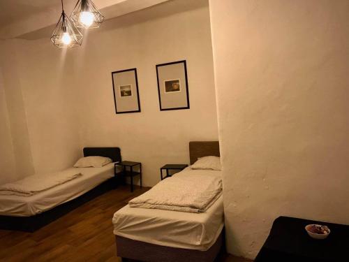 a room with two beds and two pictures on the wall at Komfort apartman in Vác
