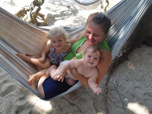 a woman and two children sitting in a hammock at Tao Thong Villa 1 in Koh Tao