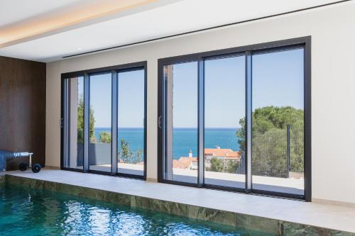 une maison avec une piscine et des fenêtres dans l'établissement Regina's Banyuls - Exclusive Villa, à Banyuls-sur-Mer