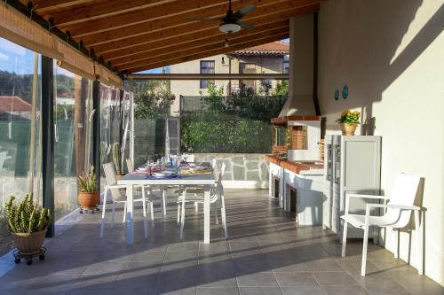 a patio with a white table and chairs on a balcony at Liotrivi Houses at Old Nikiti in Nikiti