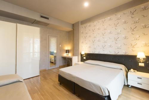 a bedroom with a bed and a wall with birds on it at Hotel San Francisco in Viareggio