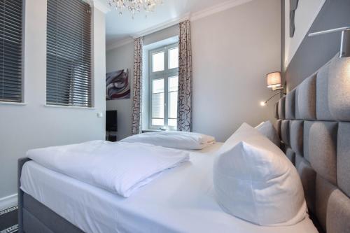 Schlafzimmer mit einem Bett mit weißer Bettwäsche und einem Fenster in der Unterkunft (61b) Villa Meeresblick 2 in Ahlbeck
