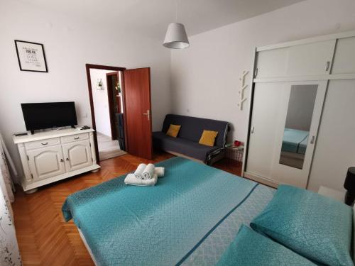 Pokój z łóżkiem, kanapą i telewizorem w obiekcie Apartments K&D w Puli