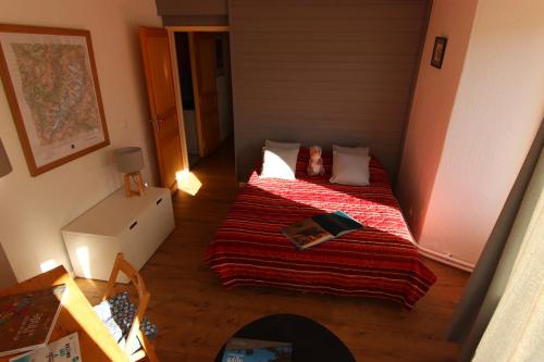 une petite chambre avec un lit avec une couverture rouge dans l'établissement Hauts De Chaviere Appartements VTI, à Val Thorens