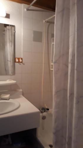 baño con lavabo y cortina de ducha en Appart situé au sein d'une résidence à Barèges pour 4 à 6 personnes, 1 chambre, 1 mezzanine, en Barèges