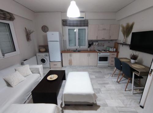 uma cozinha e sala de estar com um sofá e uma mesa em George Central Apartment em Pirgos