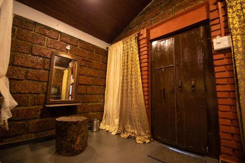 a brick room with a door and a window at Achalaa Resort in Kolhapur