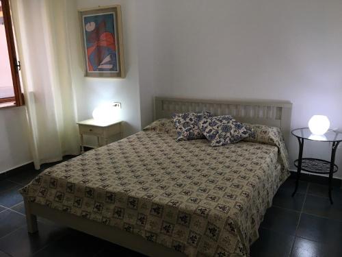 a bedroom with a bed and two tables with lamps at Vivere il mare in Palinuro