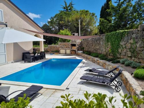 uma piscina num quintal com uma parede de pedra em Villa Bellina Muraj em Kornic