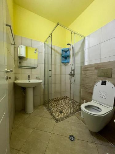 a bathroom with a shower and a toilet and a sink at Mineu Vacation Rentals in Golem