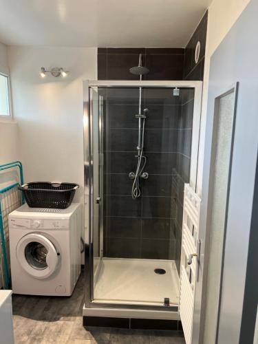 a shower in a bathroom with a washing machine at Appartement au bord de mer in Saint-Brevin-les-Pins