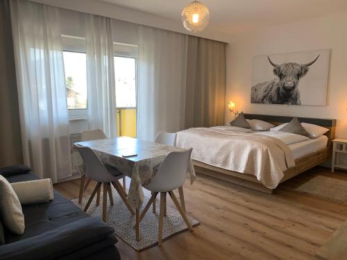 1 dormitorio con 1 cama y 1 mesa con sillas en Warmbad Apartments, en Villach