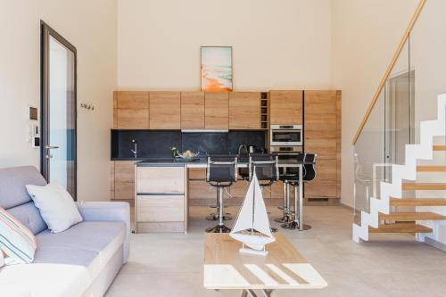 a living room with a couch and a kitchen at Regina's Banyuls - Modern and brand new apartment in Banyuls-sur-Mer