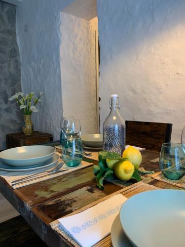 a table with plates and glasses and a bottle on it at Casa Vacanze Desirèe in Scalea
