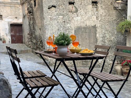 a table with a bowl of food and wine glasses at Casa Vacanze Desirèe in Scalea