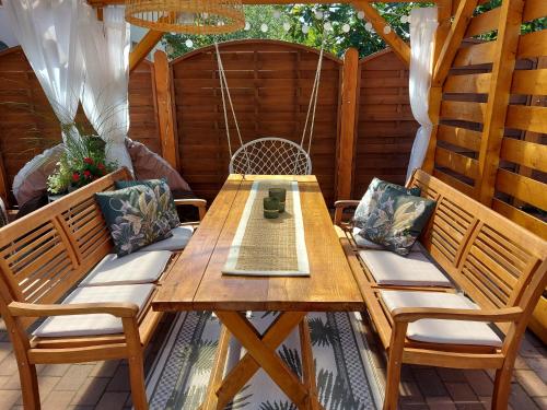 una mesa de madera y sillas en un patio en Gabi Apartmanház, en Balatonlelle