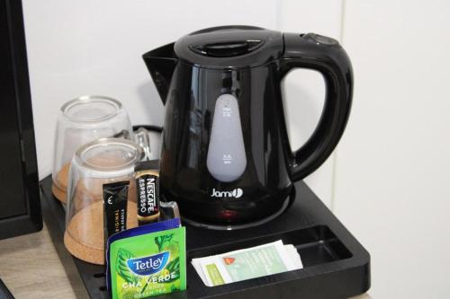 a black tea kettle sitting on top of a counter at Alojarte in Figueiros