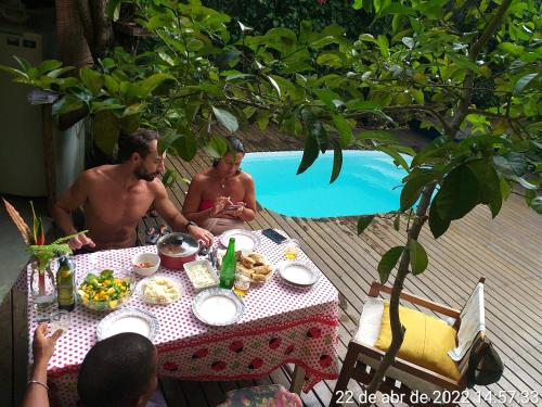 un hombre y una mujer sentados en una mesa con comida en Flor da Ilha Flats, en Isla de Boipeba