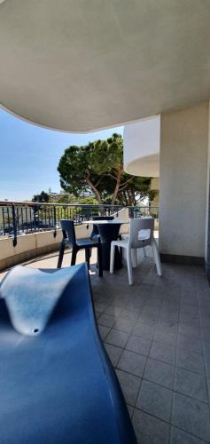 Un patio con una mesa y sillas en un balcón. en Apart Hotel Atlantic, en Grado