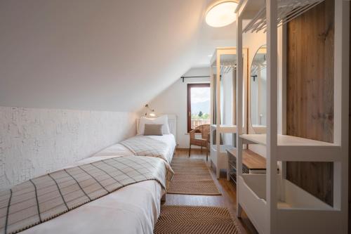 1 dormitorio con 3 camas, escritorio y ventana en GrosAlp apartments, en Lesce