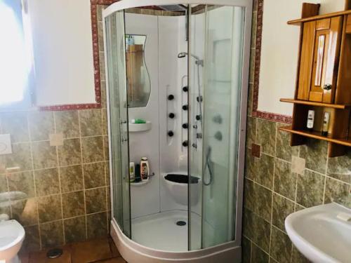 um chuveiro com uma porta de vidro na casa de banho em Trullo House em Locorotondo