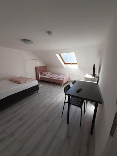 Zimmer mit einem Schreibtisch und einem Bett sowie einem Zimmer mit einem Tisch in der Unterkunft Pension Rückert in Kassel