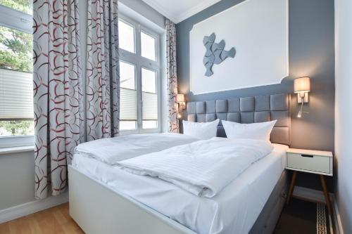 ein Schlafzimmer mit einem weißen Bett und einem Fenster in der Unterkunft (61c) Villa Meeresblick 3 in Ahlbeck