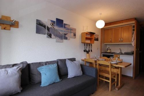 un salon avec un canapé et une table et une cuisine dans l'établissement Lauzieres Appartements VTI, à Val Thorens