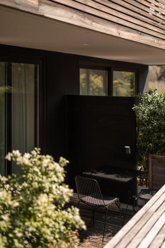a patio with a chair and a table on a house at Design Hotel Tyrol in Rablà