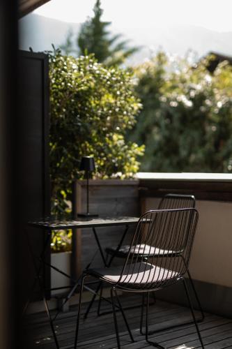 two chairs and a table on a balcony at Design Hotel Tyrol in Rablà