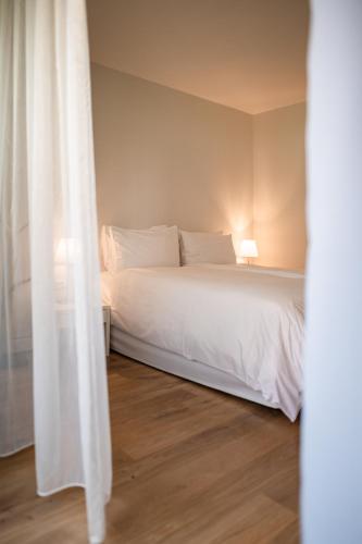 a white bed in a room with a window at Design Hotel Tyrol in Rablà