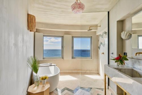 a bathroom with a bath tub and a sink at Okulus Madeira in Funchal
