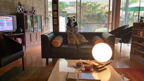a living room with a couch with a stuffed bear on it at 宮城野ハウス＆離れ in Gora