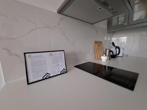 a white kitchen with a counter and a counter top at Apartament WILKASY (k. Giżycka) in Wilkasy