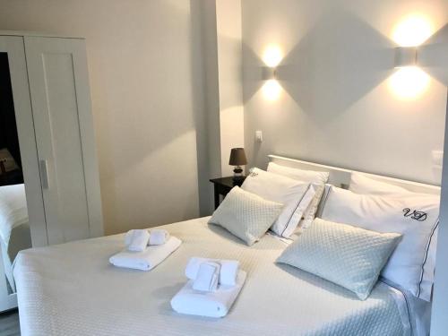a white bed with two towels on top of it at Casa Beira Rio in Viana do Castelo